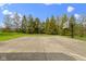 A full-size basketball court with two hoops sits amongst mature trees and a clear blue sky at 12010 Landover Ln, Fishers, IN 46037