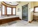 This bright bathroom features a soaking tub under a large window and a glass shower at 12010 Landover Ln, Fishers, IN 46037