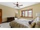 This bedroom offers neutral walls, a ceiling fan, and a large window for ample natural light at 12010 Landover Ln, Fishers, IN 46037