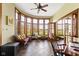 Bright sunroom with large windows offering scenic views of the outdoors and a ceiling fan at 12010 Landover Ln, Fishers, IN 46037