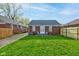 Well-manicured backyard with brick home, small patio, and new wooden fence for privacy at 1209 N Downey Ave, Indianapolis, IN 46219