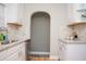Well-lit kitchen featuring white cabinets, granite countertops, and a stylish arched doorway at 1209 N Downey Ave, Indianapolis, IN 46219