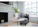 Stylish living room with a gray armchair, stone fireplace, and ample natural light, perfect for unwinding at 1209 N Downey Ave, Indianapolis, IN 46219