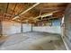 An empty two car garage featuring exposed wood ceiling rafters and concrete floor at 1212 N 10Th St, Elwood, IN 46036