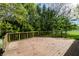 Wide backyard deck with wooden railings, set against a backdrop of mature trees and a white picket fence at 12210 Doncaster Ct, Fishers, IN 46037