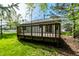 Secluded backyard featuring a wooden deck, lush lawn, and mature trees that create a private outdoor space at 12210 Doncaster Ct, Fishers, IN 46037