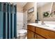 Well-lit bathroom featuring a shower-tub combo, wooden vanity, and tasteful decorative accents at 12210 Doncaster Ct, Fishers, IN 46037