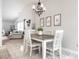 Bright dining area featuring a rustic table and modern chandelier, adjacent to a cozy living room at 12210 Doncaster Ct, Fishers, IN 46037