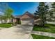 Brick home featuring a two-car garage, a well-kept lawn, and mature landscaping in a quiet neighborhood at 12210 Doncaster Ct, Fishers, IN 46037