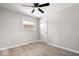 This is a bright bedroom with a ceiling fan, light gray walls, and light wood flooring at 1243 N Post Rd, Indianapolis, IN 46219