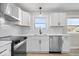 Close up of modern kitchen features white cabinets, stainless steel appliances, and marble countertops at 1243 N Post Rd, Indianapolis, IN 46219