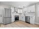 Modern kitchen features white cabinets, stainless steel appliances, new vinyl floors, and marble countertops at 1243 N Post Rd, Indianapolis, IN 46219
