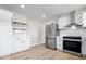 Modern kitchen features white cabinets, stainless steel appliances, new vinyl floors, and marble countertops at 1243 N Post Rd, Indianapolis, IN 46219
