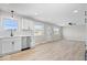 Open concept of the living room and kitchen with natural light, white walls, and new vinyl floors at 1243 N Post Rd, Indianapolis, IN 46219