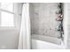 Clean and modern bathroom with tiled walls, a shower curtain, and a convenient storage shelf for toiletries at 12577 Pointer Pl, Fishers, IN 46038