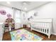 bedroom with crib, doll house, colorful floor mat, and natural light from the window at 12577 Pointer Pl, Fishers, IN 46038