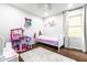 Bright bedroom with a twin bed, dollhouse, and a soft rug on wood floors at 12577 Pointer Pl, Fishers, IN 46038