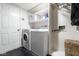 Laundry room with white washer and dryer, white shelving, door, and dark tile floors at 12577 Pointer Pl, Fishers, IN 46038