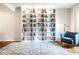 Bright living room featuring hardwood floors, a large area rug, and custom built-in bookshelves at 12577 Pointer Pl, Fishers, IN 46038