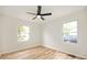 Bright bedroom featuring wood-look floors, a modern ceiling fan, and plenty of natural light from two windows at 1295 Rolling Ridge Dr, Noblesville, IN 46060