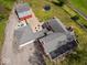 Aerial view of a property featuring a house with a gray roof, barn, and outdoor seating area, set in a lush landscape at 1394 N Michigan Rd, Shelbyville, IN 46176