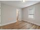 Bedroom with wood flooring, white walls, bright window and access to another room at 1627 Lawton Ave, Indianapolis, IN 46203