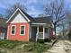 Charming single-story home with orange siding, covered porch, and well-maintained landscaping at 1824 Spann Ave, Indianapolis, IN 46203