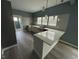Modern kitchen features white cabinets, grey backsplash, stainless steel sink, and light-colored wood floors at 1824 Spann Ave, Indianapolis, IN 46203