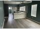 Open-concept kitchen and dining area with modern lighting, light wood floors, and stylish grey backsplash at 1824 Spann Ave, Indianapolis, IN 46203