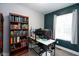 Cozy office with a large bookshelf, computer, and a window that allows natural light to flood the space at 1835 N Rural St, Indianapolis, IN 46218