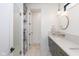Modern bathroom featuring a marble tiled floor, green vanity, round mirror, and glass enclosed shower at 1907 N Alabama St, Indianapolis, IN 46202
