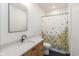 Bathroom featuring a light wood vanity, marble countertop, black fixtures, and a floral shower curtain at 1907 N Alabama St, Indianapolis, IN 46202
