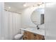 Bathroom featuring a wooden vanity with a marble countertop, shower with curtain, and modern fixtures at 1907 N Alabama St, Indianapolis, IN 46202