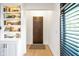 Bright entryway featuring hardwood floors, custom built-in shelving, and a view of the modern front door at 1907 N Alabama St, Indianapolis, IN 46202