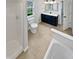 Well-lit bathroom with a navy vanity, tile floors, and a shower-tub combination at 2080 Norwich Pl, Martinsville, IN 46151