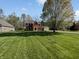 Beautiful red brick home with a green lawn and mature trees at 2080 Norwich Pl, Martinsville, IN 46151
