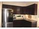 Contemporary kitchen showcasing dark cabinets, granite countertops, and stainless steel refrigerator at 2120 Dakota Dr, Franklin, IN 46131