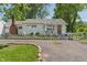 Charming single-story home with white siding, brick chimney, and a small picket fence at 219 S Sherman Dr, Indianapolis, IN 46201