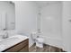 Bright bathroom features a wood cabinet vanity, tub, and a toilet atop a plank flooring at 2257 Aviary Ln, Danville, IN 46122