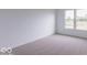 Clean, minimalist bedroom with neutral carpet, white walls, and natural light pouring in from the large window at 2257 Aviary Ln, Danville, IN 46122