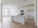 Bright, open kitchen with white cabinets, a center island, stainless steel appliances, and wood-look floors at 2257 Aviary Ln, Danville, IN 46122