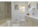 Well-lit bathroom featuring a tub, neutral tile, and decorative accents at 2325 Melody Ln, Anderson, IN 46012
