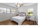 Bright bedroom featuring multiple windows, hardwood floors, stylish decor, and comfortable bedding at 2325 Melody Ln, Anderson, IN 46012