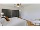 Comfortable bedroom with hardwood floors, a ceiling fan, dark closet doors, and a cozy chair at 2325 Melody Ln, Anderson, IN 46012