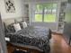 Bright bedroom with patterned bedding, built-in shelves, and a large window offering a scenic view at 2325 Melody Ln, Anderson, IN 46012