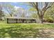Charming single-story home featuring a brick and stone facade, well-manicured lawn and large shade tree at 2325 Melody Ln, Anderson, IN 46012
