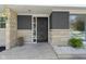 Inviting front entrance with a decorative black door, stone accents, and stylish plants at 2325 Melody Ln, Anderson, IN 46012