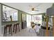 Well-lit living room with cozy gray couch, bar-stool seating and windows overlooking the backyard at 2325 Melody Ln, Anderson, IN 46012