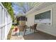 Covered patio area with wicker chairs, white fence, and a landscaped garden at 2325 Melody Ln, Anderson, IN 46012