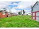 Expansive backyard featuring lush green grass, a storage shed, and a brick home in a residential neighborhood at 2610 S Sheridan Ave, Indianapolis, IN 46203